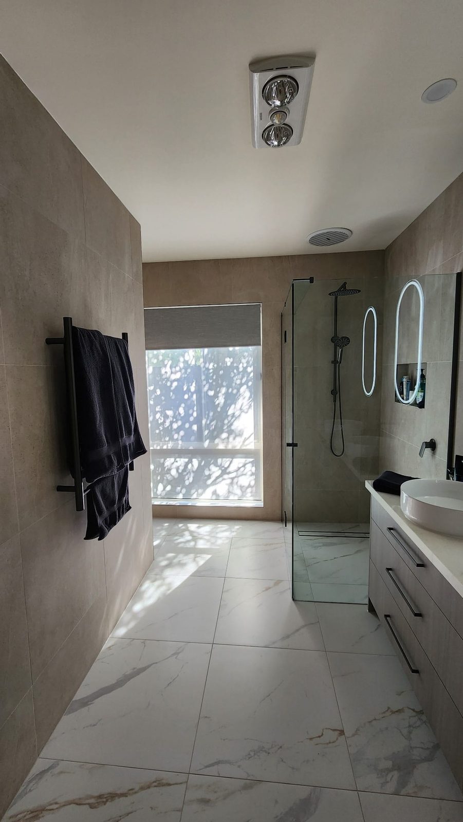 Matte black tapware, rainfall shower head and towel rail